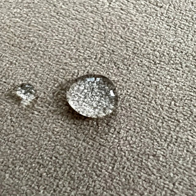 Wasserabweisende und pfelgeleichte Ausrüstung durch Wassertropfen auf Velourstoff dargestellt