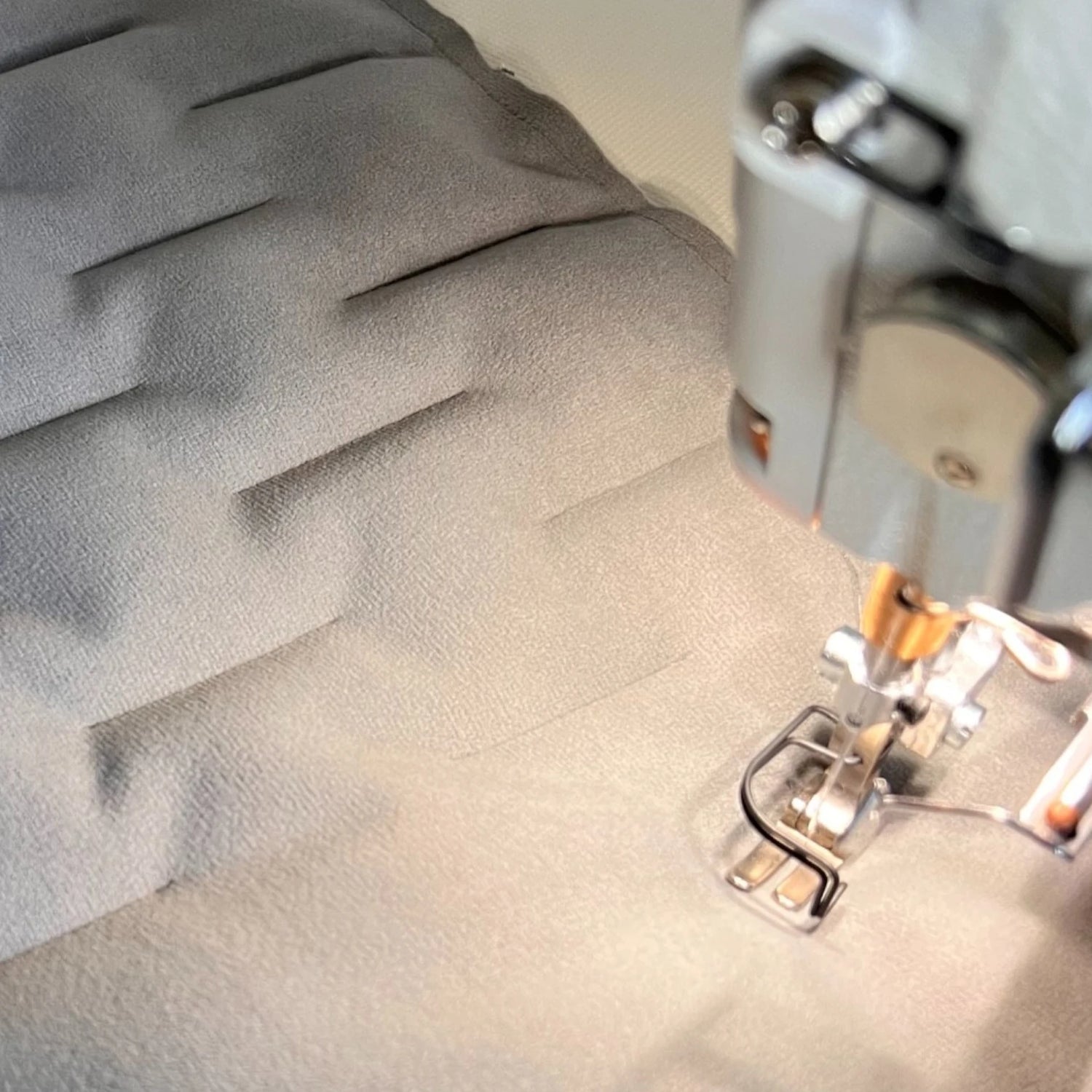 Stoffteile unter Nähmaschinenfuß mit handgefertigten Steppungen