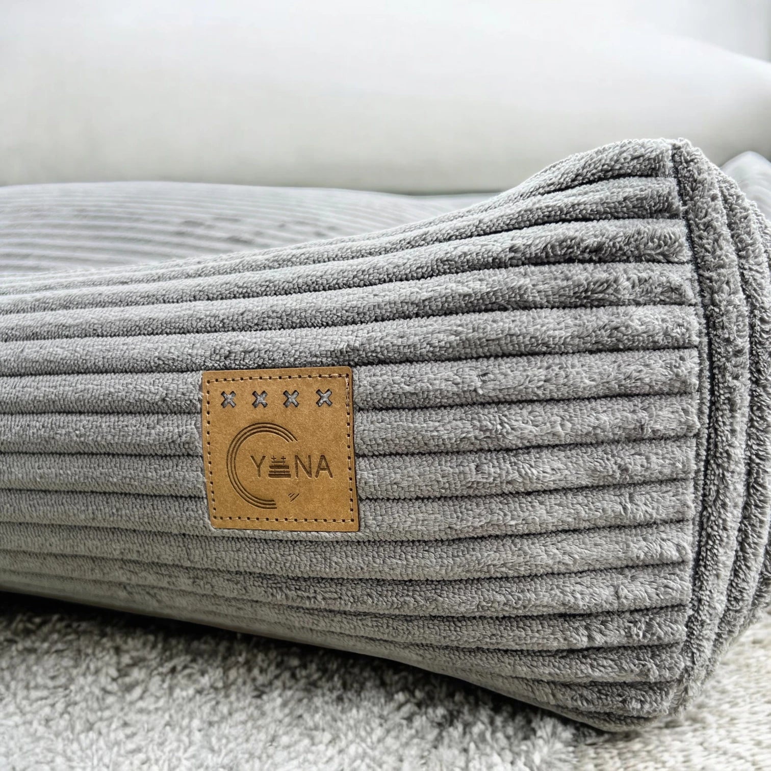 Detailansicht grauer Breitcord Stoff mit aufgenähtem Label Yuna