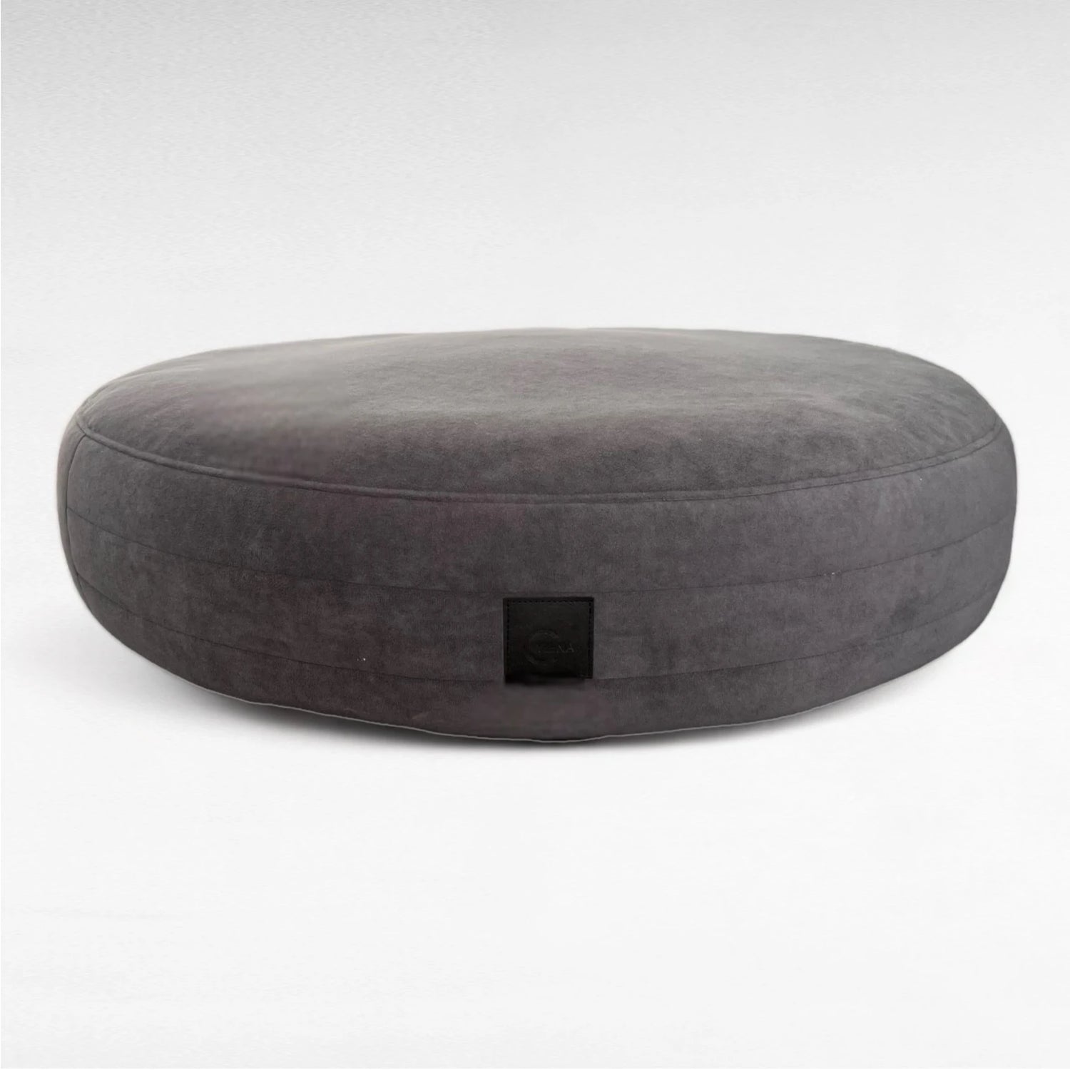 Dunkelgraues rundes Hundebett Yumi mit rundherum laufenden Steppungen uns schwarzem Yuna Label