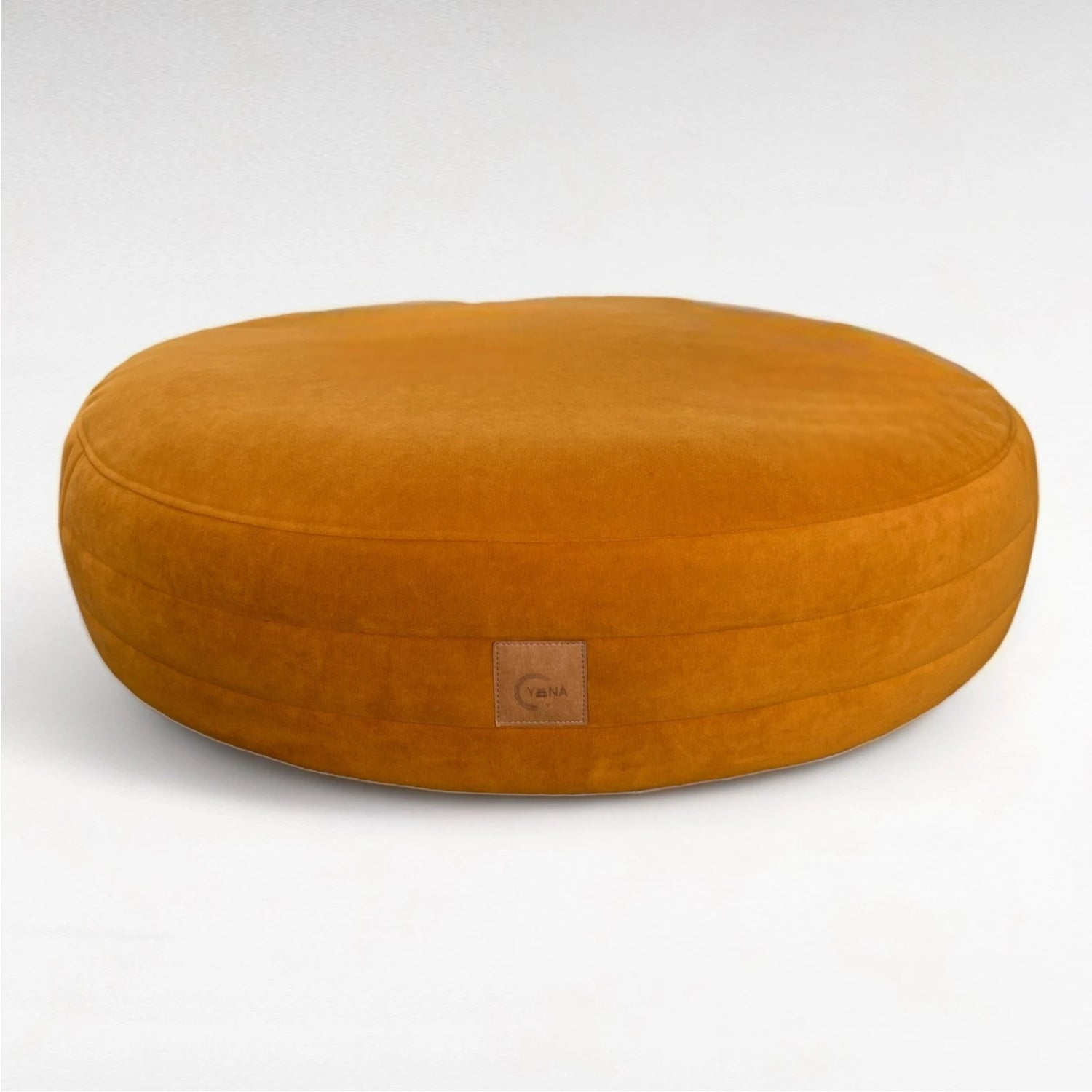 Safranfarbenes rundes Hundebett Yumi mit rundherum laufenden Steppungen und Yuna Label