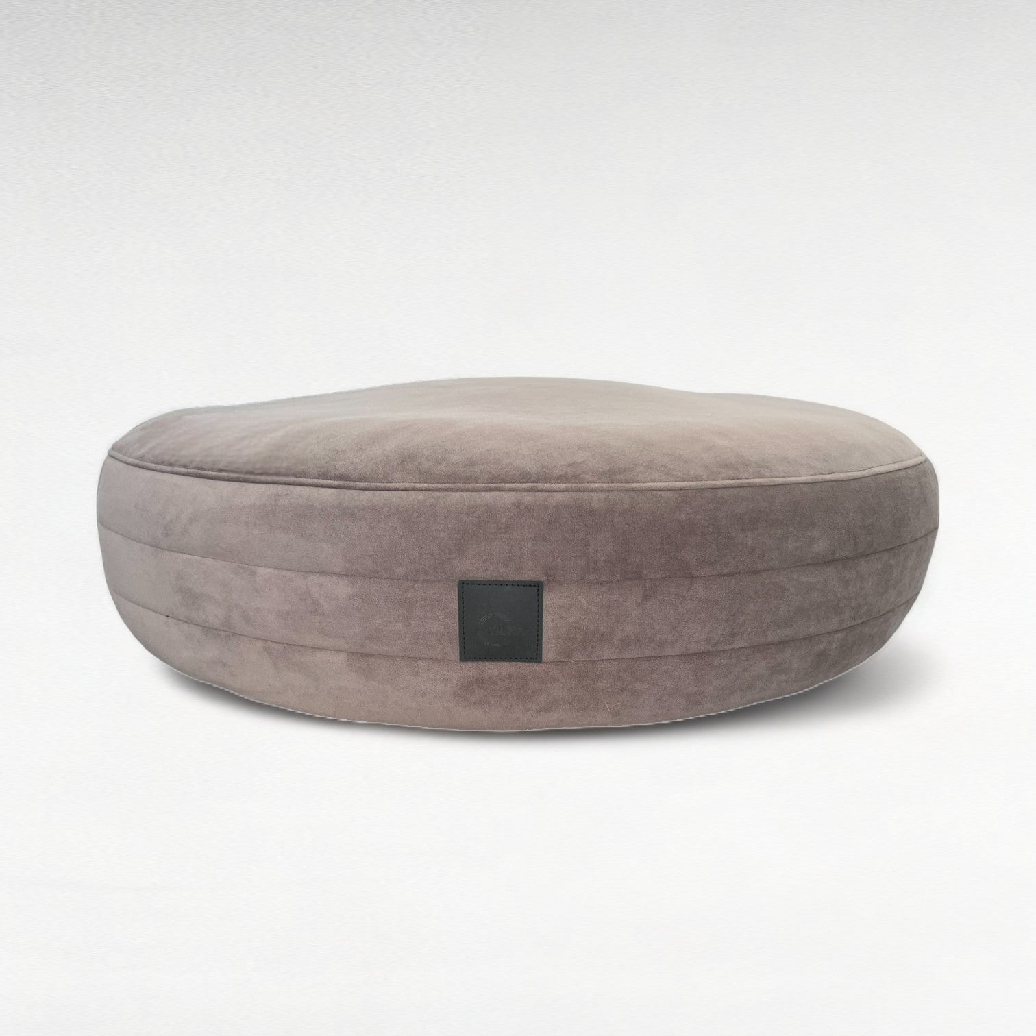 Taupefarbenes rundes Hundebett mit seitlichen 3D Steppungen mit Microfaserbezug und schwarzem Logoetikett