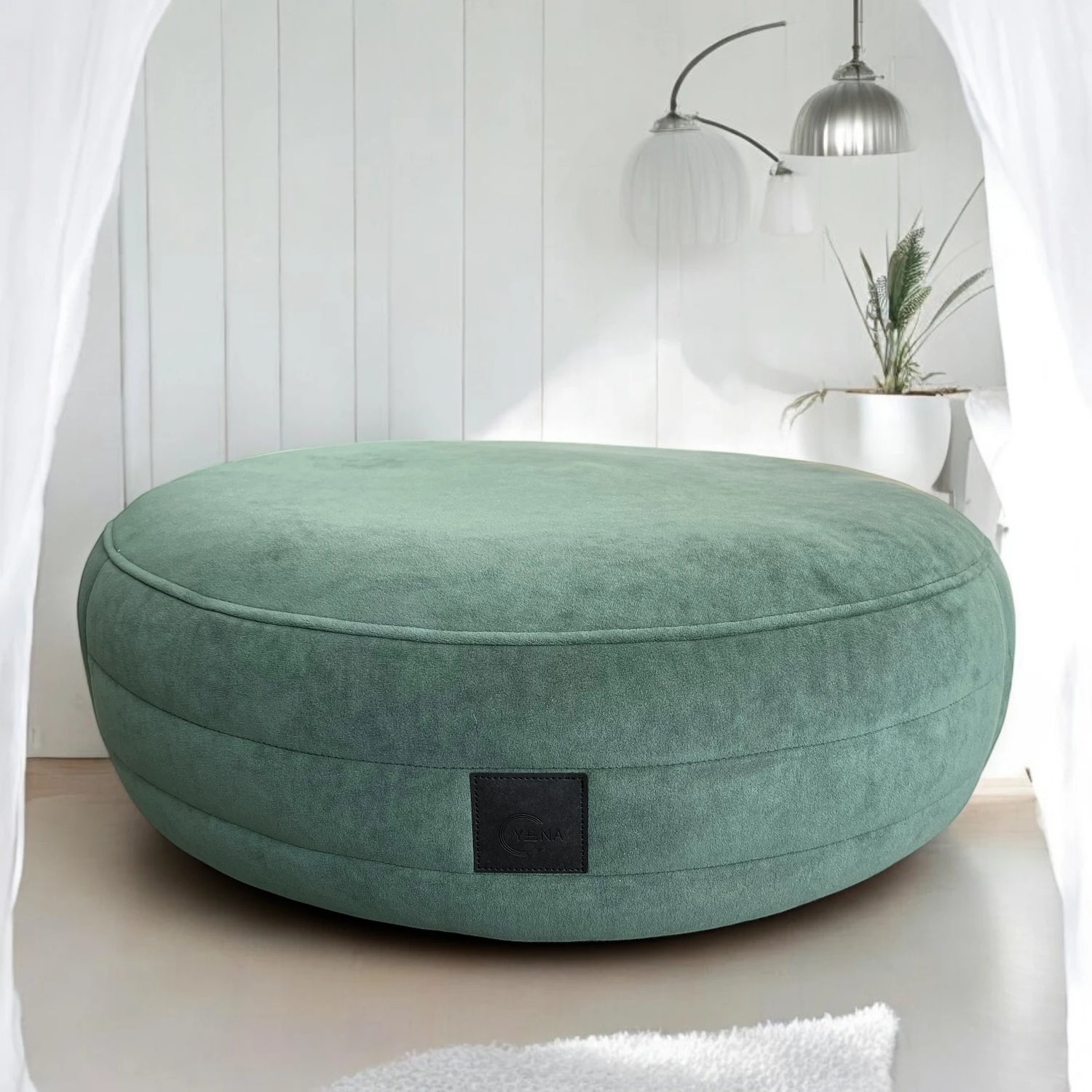 Smaragdgrünes rundes Hundebett Yumi mit rundherum laufenden Steppungen uns schwarzem Yuna Label mit minimalistischem Hintergrund