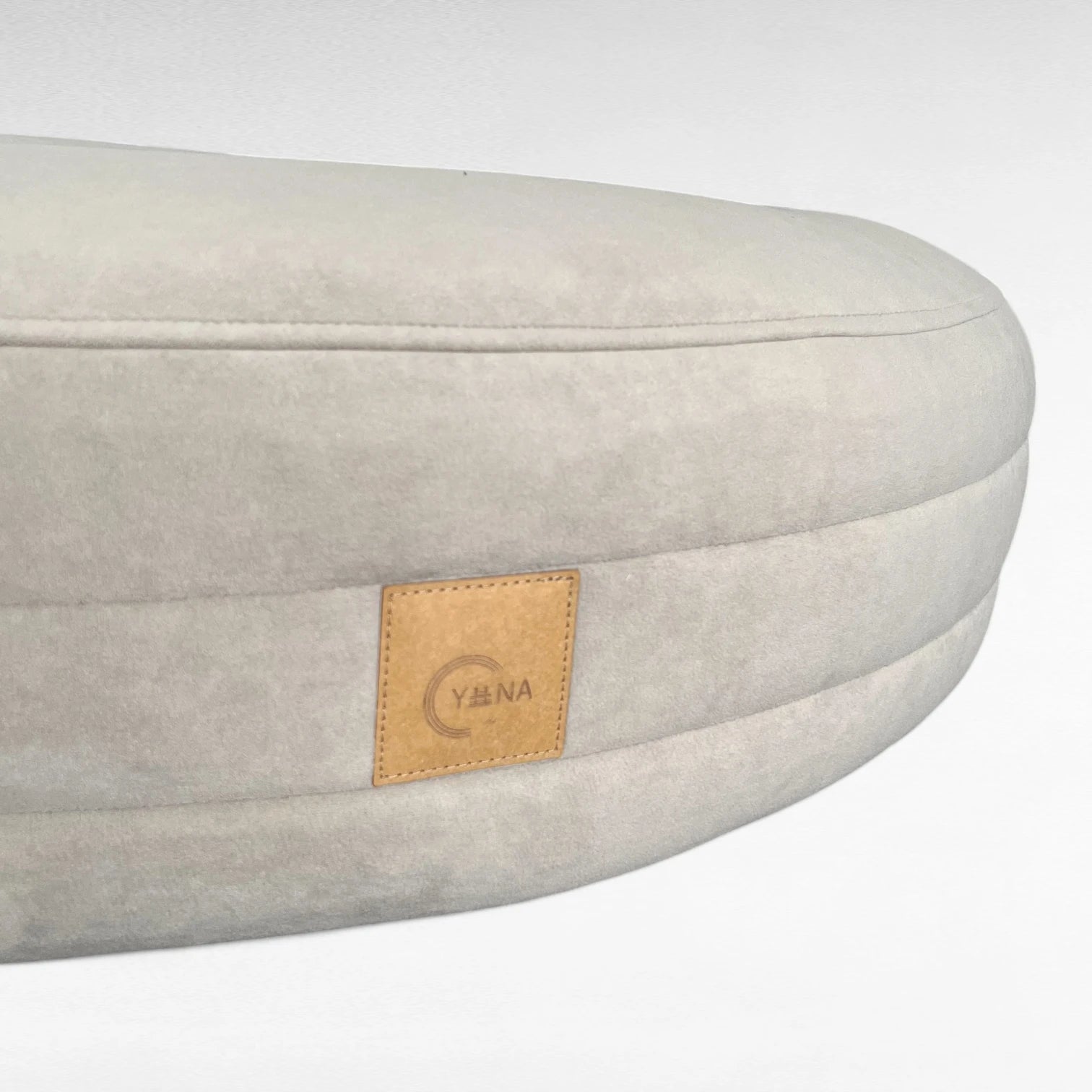 Nahaufnahme rundherum laufende Steppungen mit Yuna Label rundes Hundebett Yumi Farbe greige