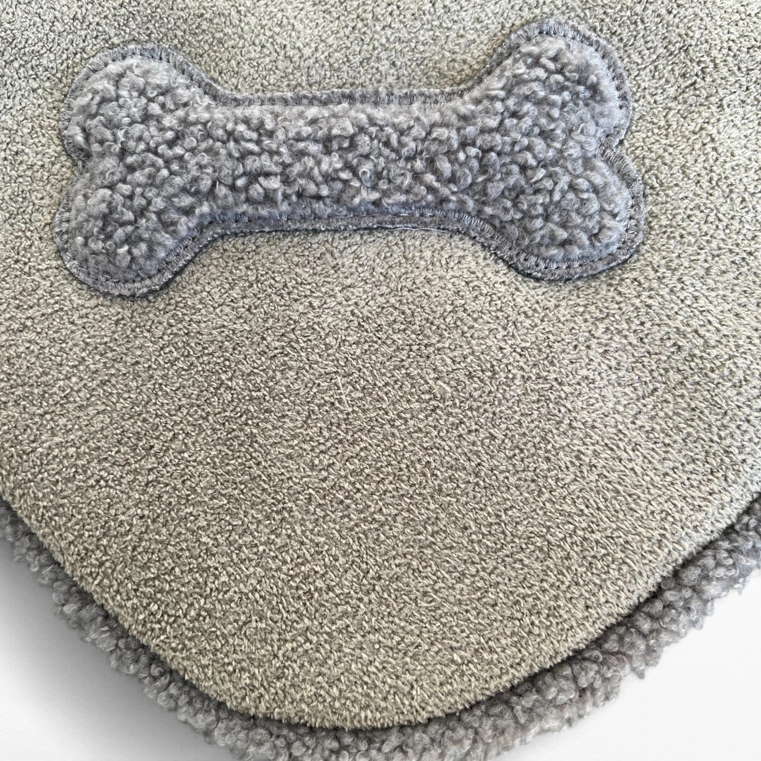 Detailansicht knochenförmige Teddyapplikation in Ecke auf Hundedecke
