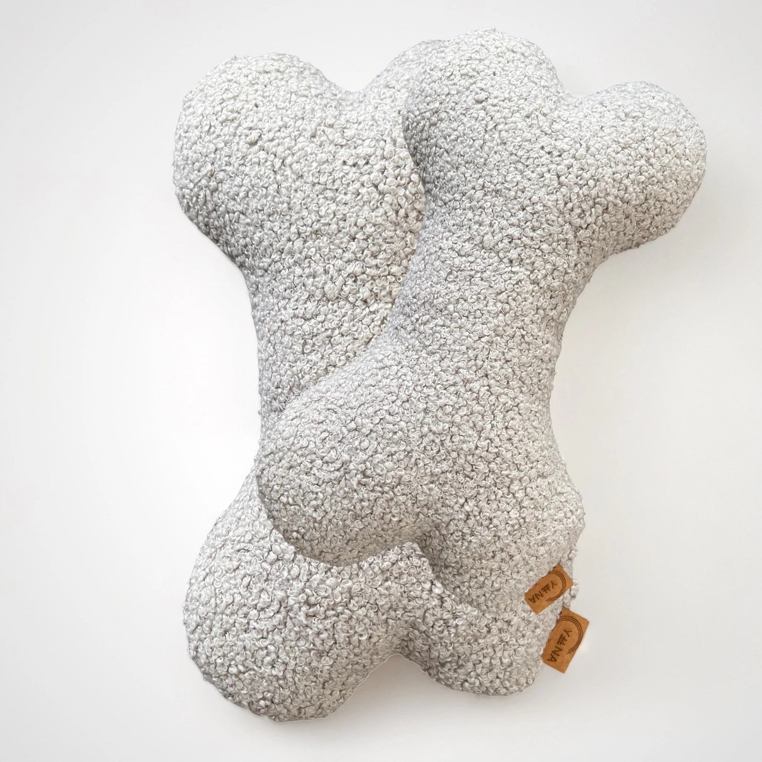 2 Hundekissen in Knochenform aus Boucléstoff in hellgrau