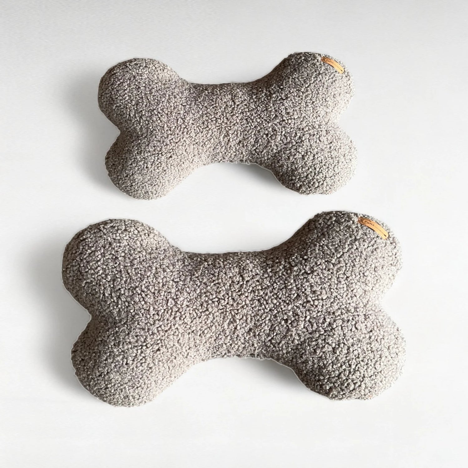 2 Hundekissen in Knochenform aus Boucléstoff in grau