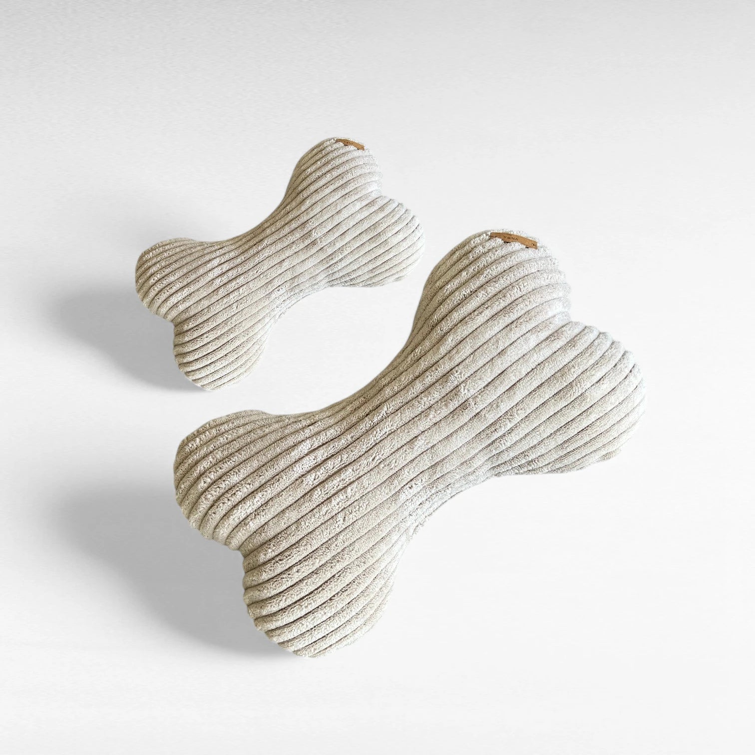 1 kleines Hundekissen und 1 mittelgroßes Hundekissen, beide in Knochenform aus Breitcord in Farbe beige