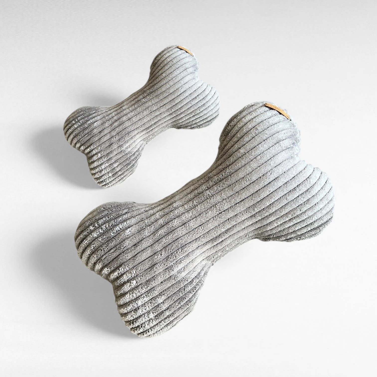 1 kleines Hundekissen und 1 mittelgroßes Hundekissen, beide in Knochenform aus Breitcord in Farbe grau