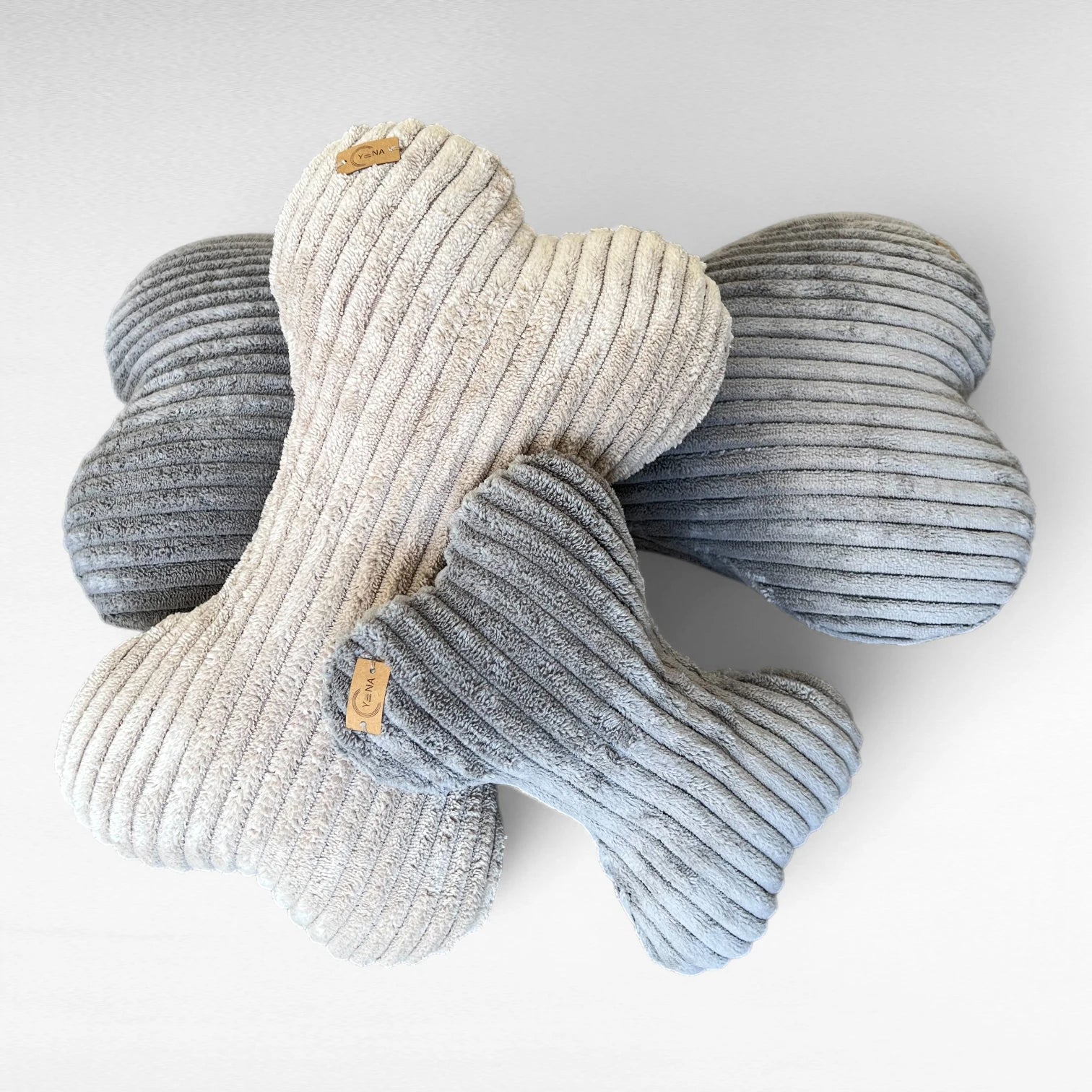 3 Hundekissen in Knochenform in 3 verschiedenen Größen aus Breitcord in 2 Farben beige und grau übereinander gelegt