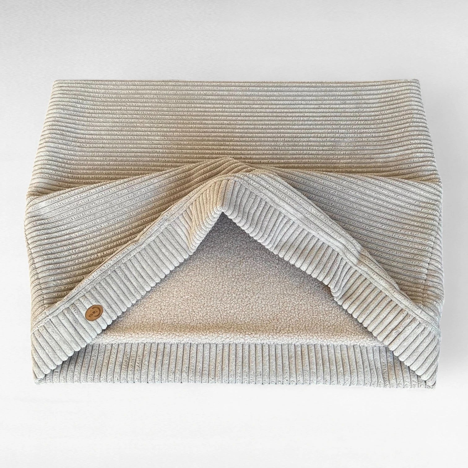 Hundeschlafsack liegend und teilweise geöffnet aus beigem Breitcord aussen und beigem Teddystoff innen