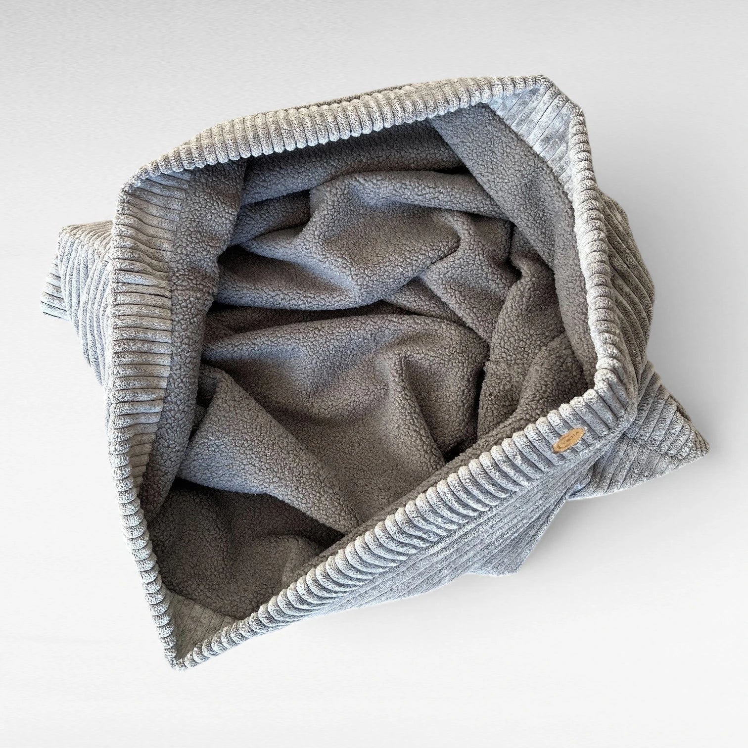 Hundschlafsack aus grauem Breitcord aussen und grauem Teddy innen zum Kuschelnest gelegt