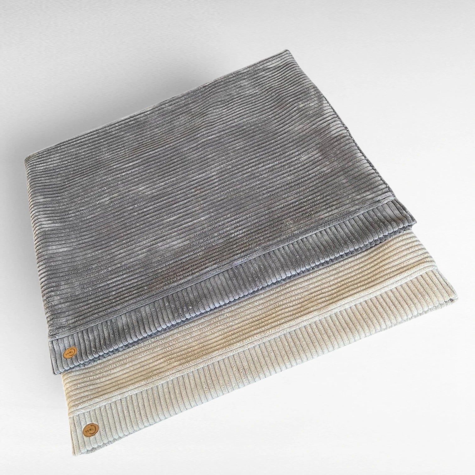 2 rechteckige Hundeschlafsäcke aus Breitcord halb übereinander gelegt. Oben liegt Farbe grau und darunter Farbe beige