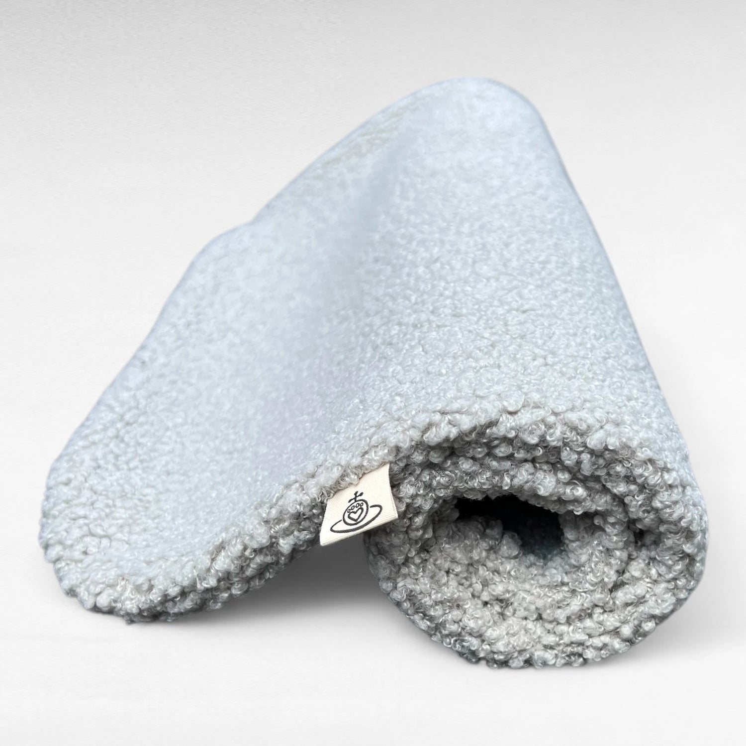 Hundedecke aus flauschigem Bouclé Stoff in hellgrau gerollt