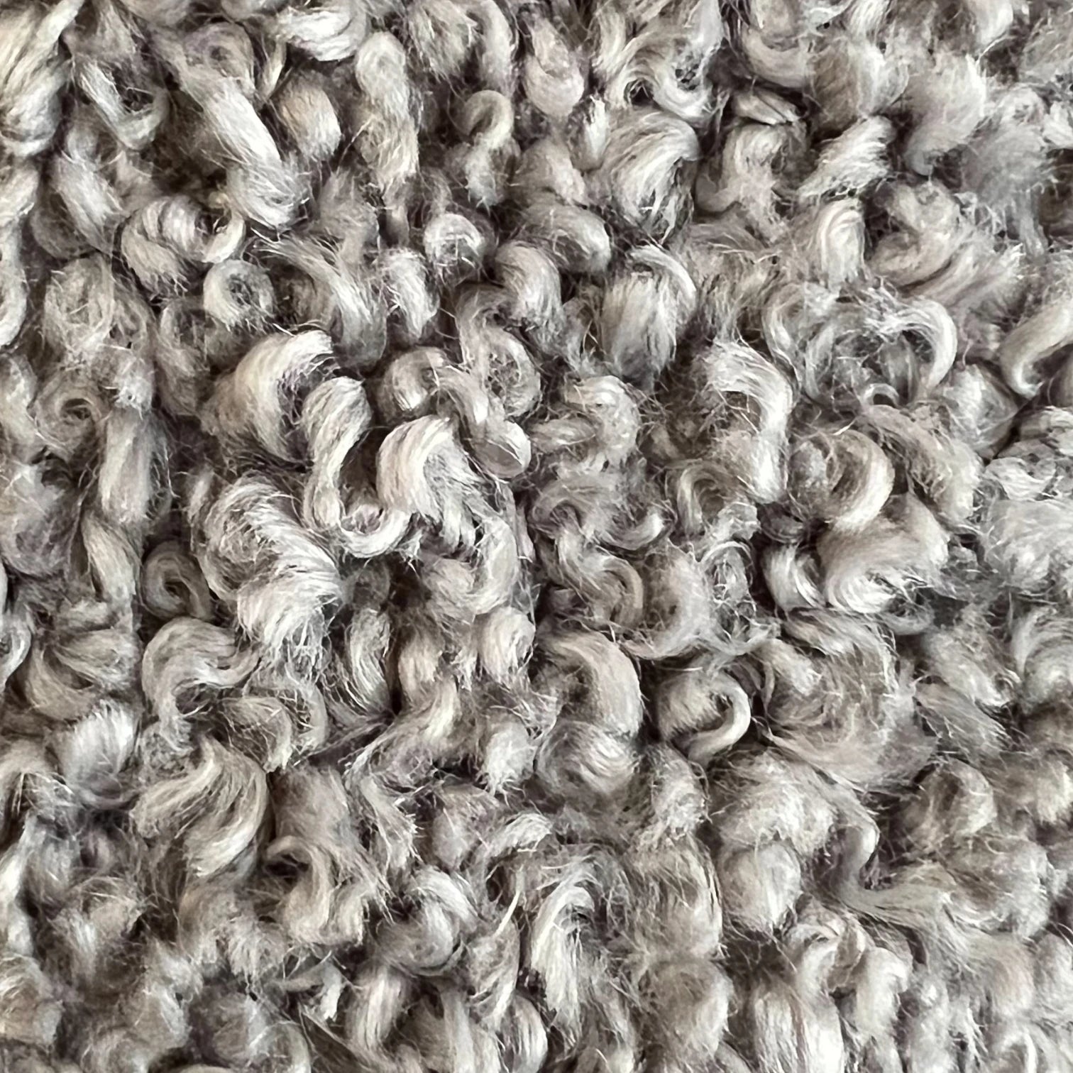 Nahufnahme des besonders kuschelig luxuriösem Curly Plush Stoff in silbergrau