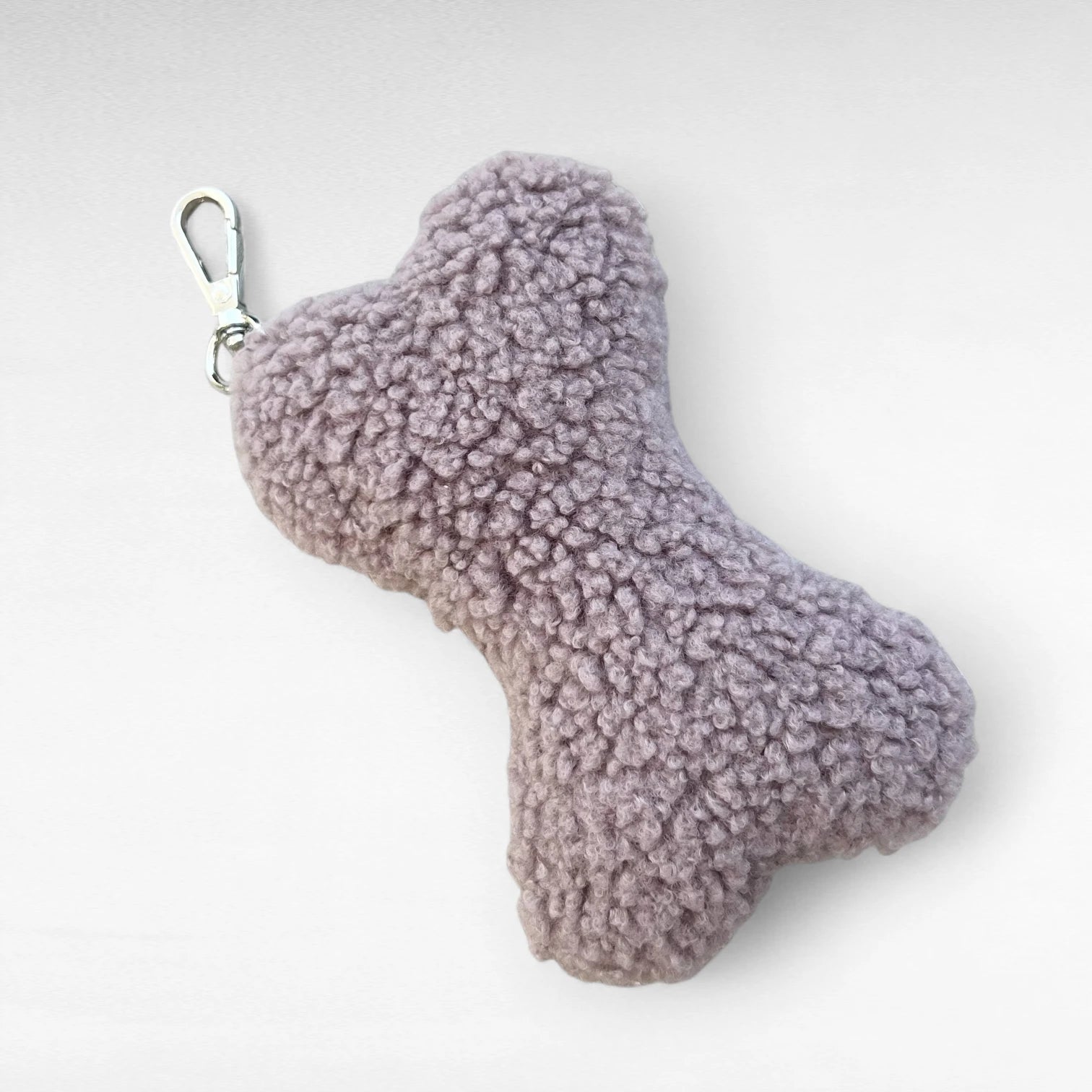 Knochenförmiges kleines Boucle-Kissen mit Karabinerhaken als Taschenanhänger in Farbe altrosa