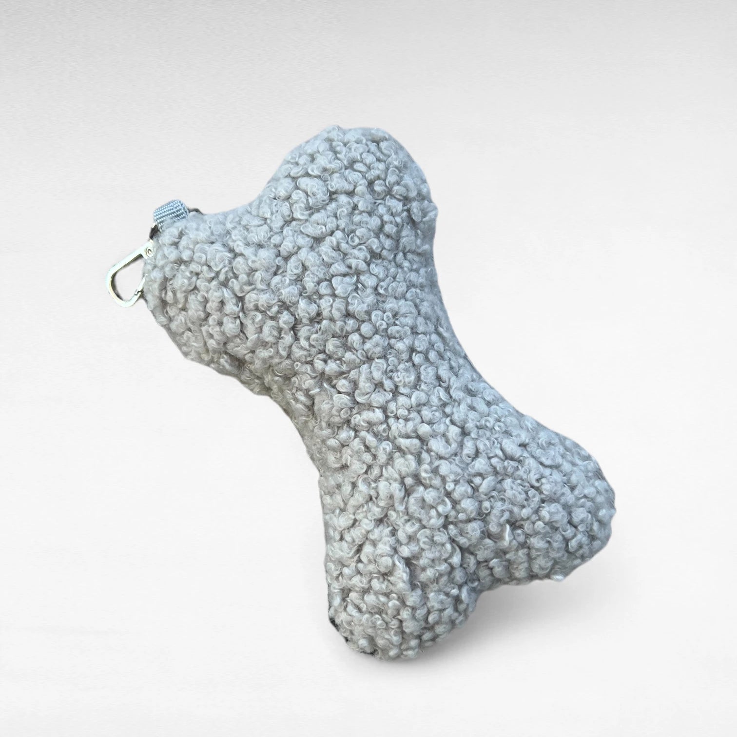 Knochenförmiges kleines Boucle-Kissen mit Karabinerhaken als Taschenanhänger in Farbe hellgrau