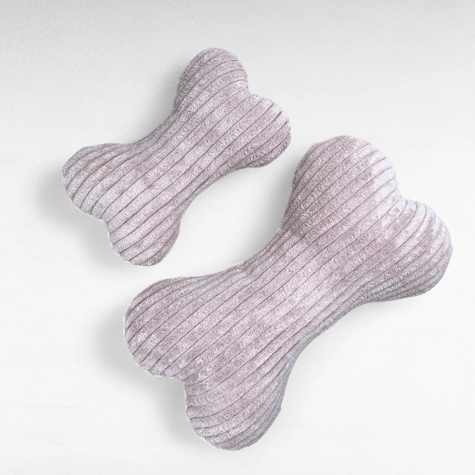 1 kleines Hundekissen und 1 mittelgroßes Hundekissen, beide in Knochenform aus kuscheligen Breitcord in Farbe pastellrosa