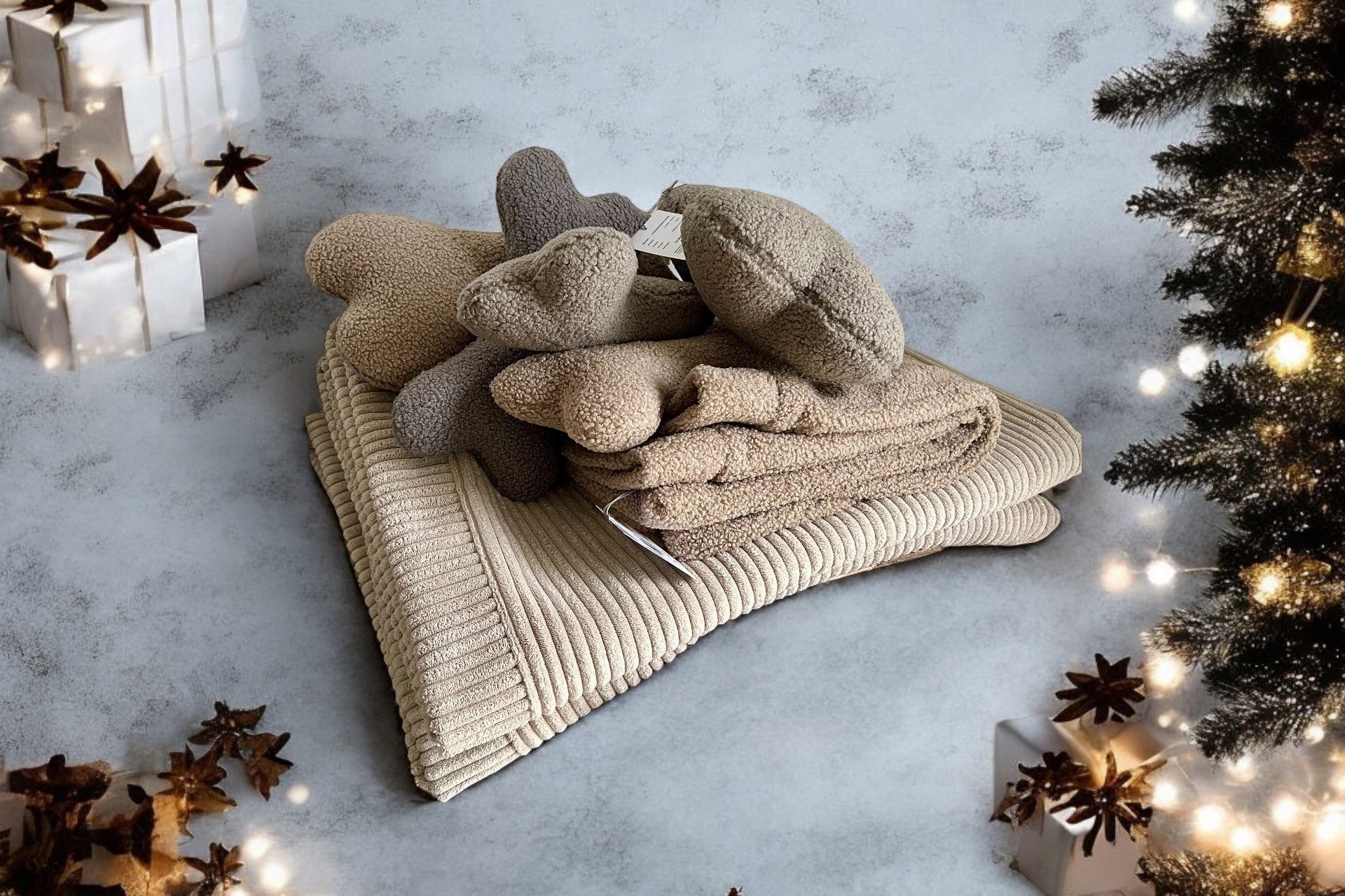 Stapel Kuschelhundedecken und Kissen aus Cord und Teddy mit Weihnachtsdeko im Hintergrund