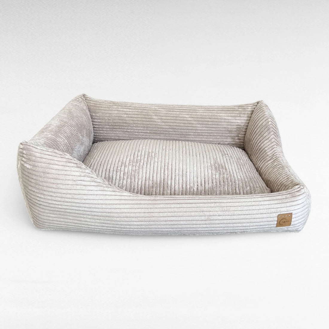Frontansicht rechteckiges Hundebett mit asymmetrischem Polsterrand aus beige farbenen Breitcord 