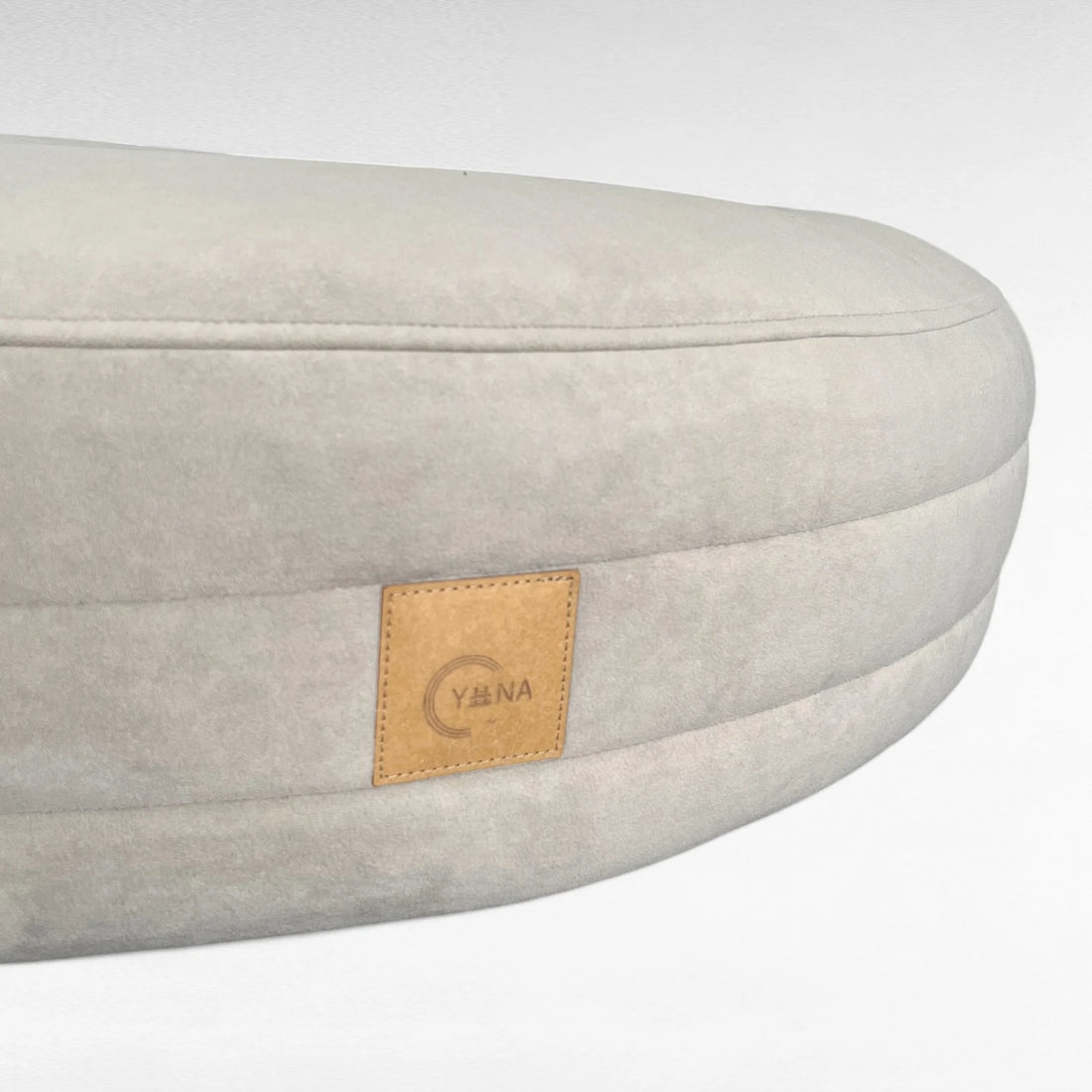 Nahaufnahme rundherum laufende Steppungen mit Yuna Label rundes Hundebett Yumi Farbe greige
