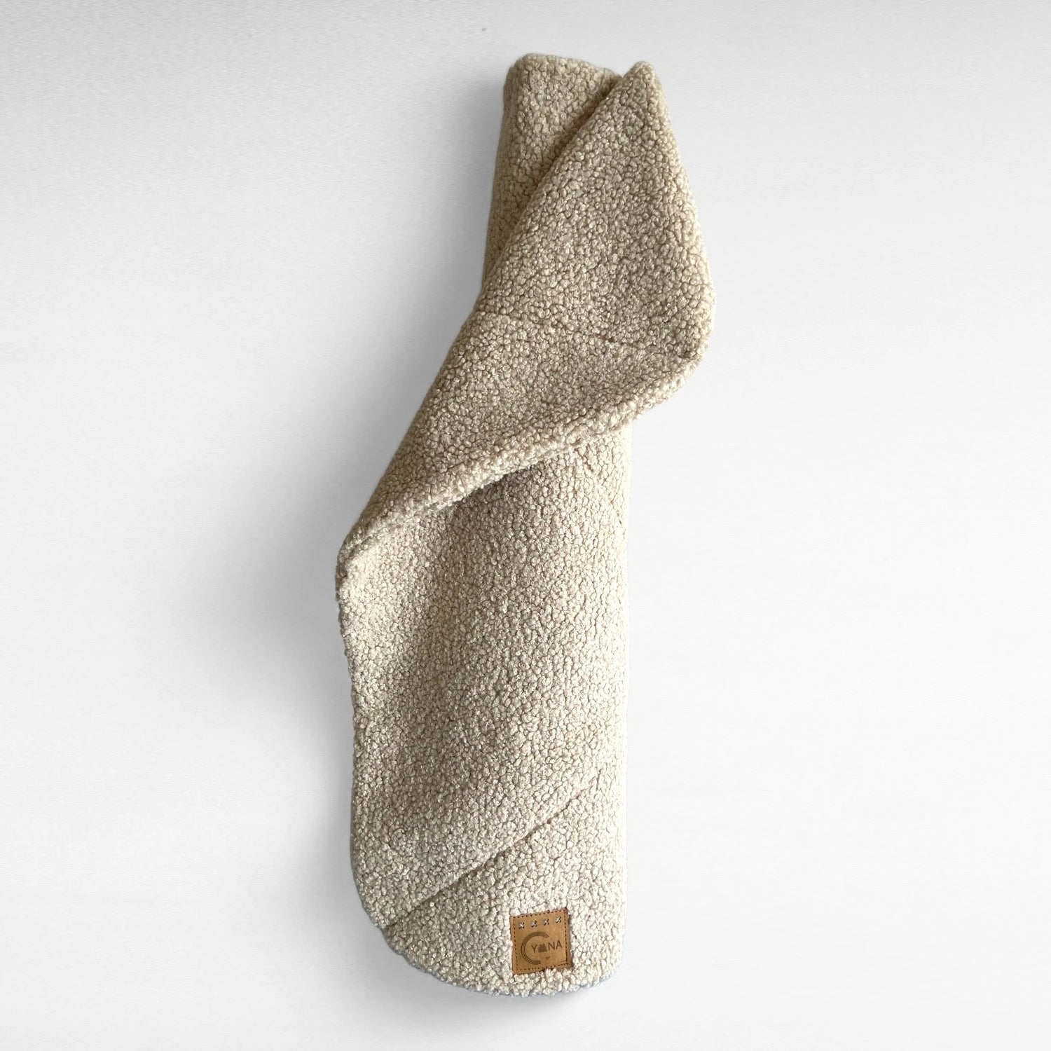 Beige rechteckige Hundedecke mit abgerundeten Ecke und Ziersteppungen aus hochwertigem Boucle-Stoff gerollt