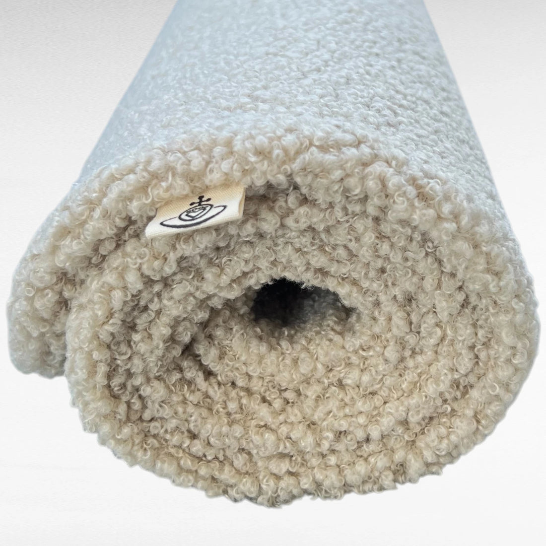 Warme und kuschelige Hundedecke aus hochwertigem und voluminösem Boucle Stoff mit wollartiger Haptik in gerollter Form in Farbe beige