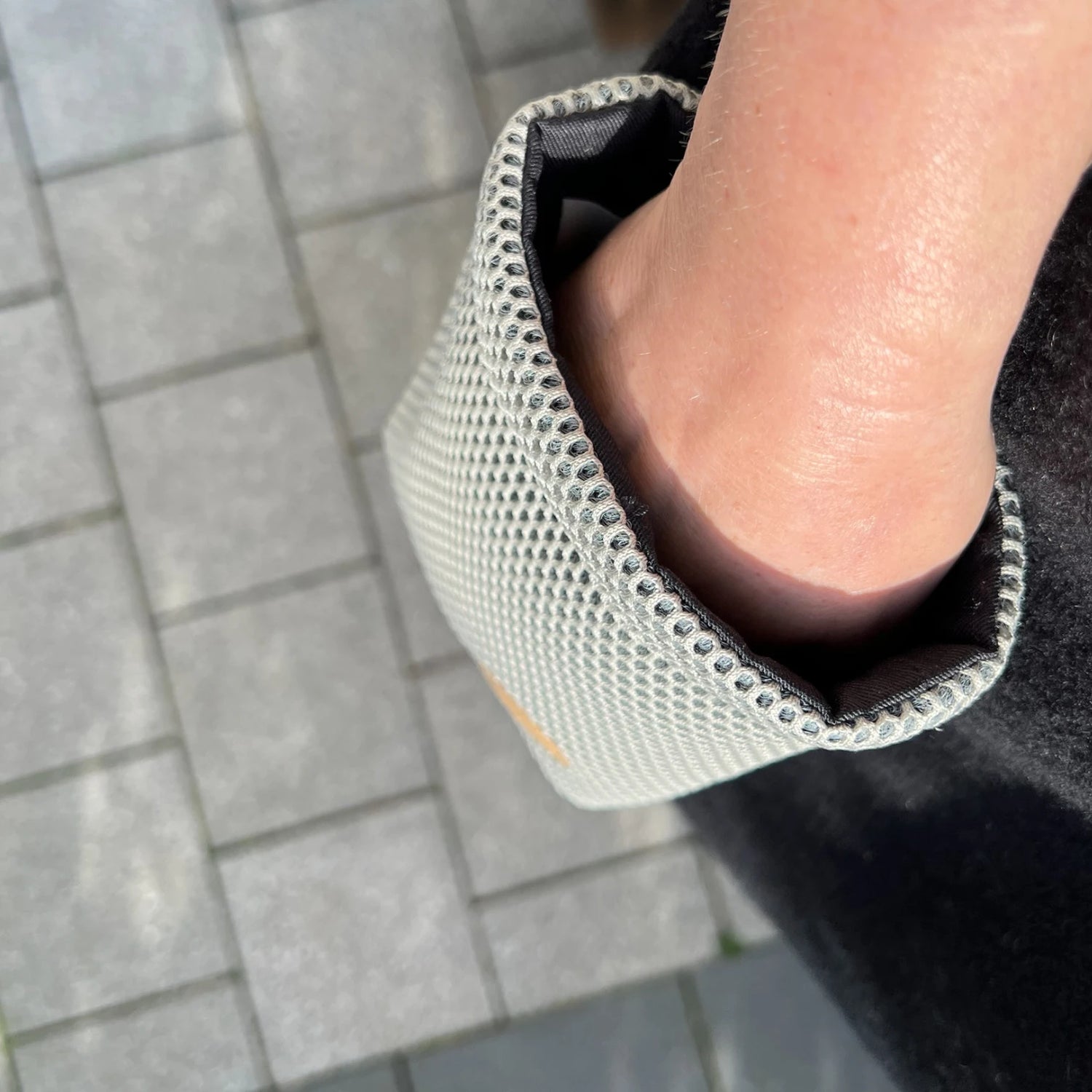 Hand in Rechteckigem Leckeribeutel mit Metallkarabiner aus Mesh Material in Farbe beige