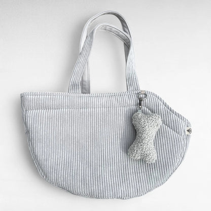 Halbrunde Hundetasche aus Cord hellgrau mit 2 Tragegurten aus Cordstoff, sowie silberner O-Ring und Taschenanhänger in Knochenform in Boucle hellgrau